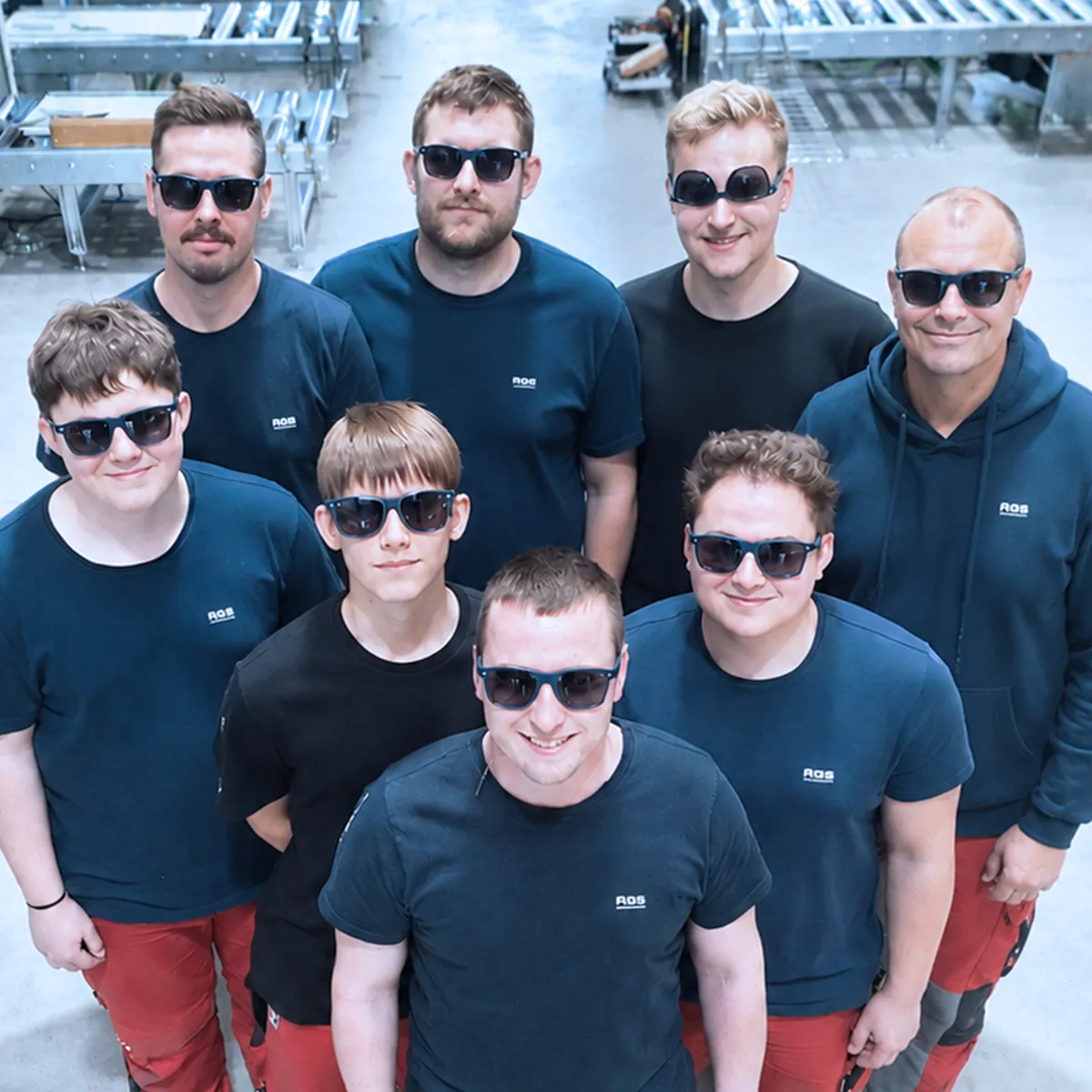 AGS-Team mit Sonnenbrillen in der Fertigungshalle