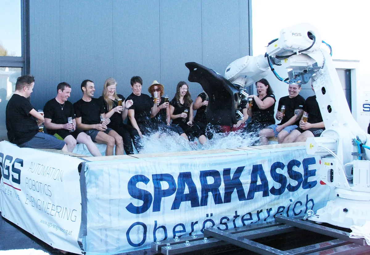 AGS-Team im Pool beim Sommerfest mit Sparkasse-Banner