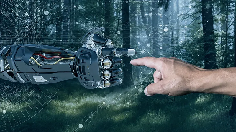 Roboterhand und Menschenhand vor Waldkulisse