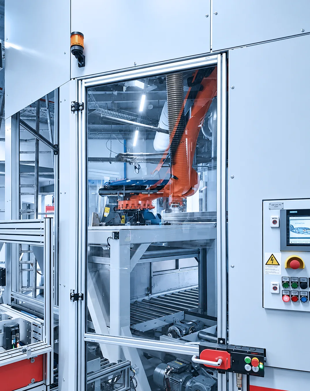 Blick in die Schutzeinhausung mit Rollenbahn und Bedienpanel