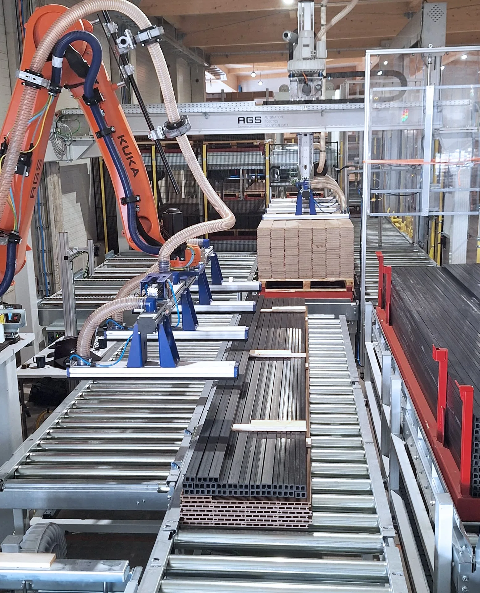 Roboter mit Traversengreifer beim Aufbau eines Dielenpakets