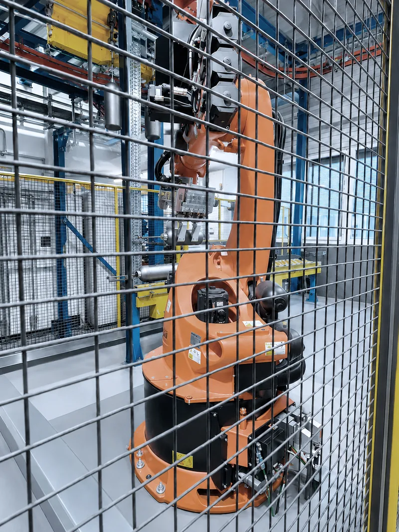 Schwerlastroboter hinter Schutzzaun in der modernisierten Roboterzelle